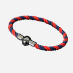Un bracelet cordon rouge et bleu marine fermé par un fermoir métallique.