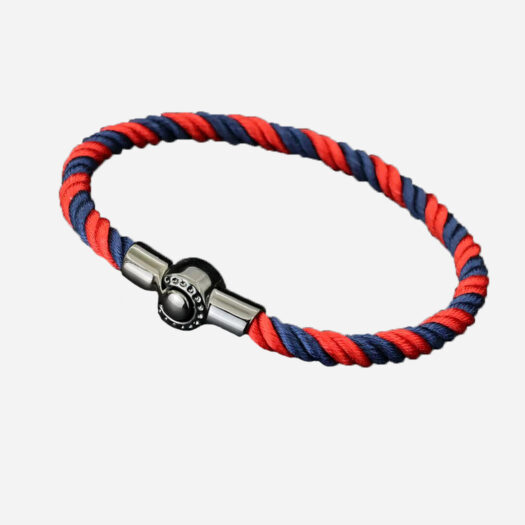Un bracelet cordon rouge et bleu marine fermé par un fermoir métallique.