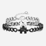 Photo d'un bracelet couple l'un noir et l'autre argenté avec un puzzle formant un coeur en zircons une fois réunis.