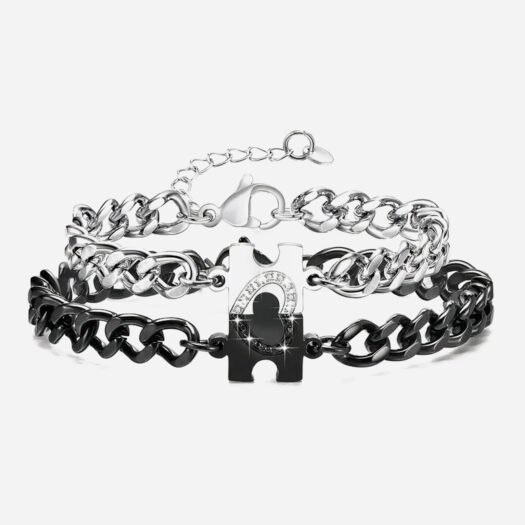 Photo d'un bracelet couple l'un noir et l'autre argenté avec un puzzle formant un coeur en zircons une fois réunis.