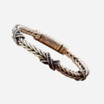 Photo d'un bracelet en argent sterling 925 à maille palmier avec motifs en X incrustés de zircons verts.