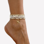 Photo d'un bracelet de cheville multi rangs multicolore en petites perles avec une breloque étoile de mer en pendentif porté