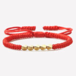 Bracelet rouge tissé avec perles dorées style tibétain
