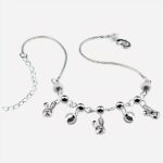 Photo d'un bracelet de cheville pour femme à breloques en forme de petits lapins sur un décor bleu turquoise comme une piscine