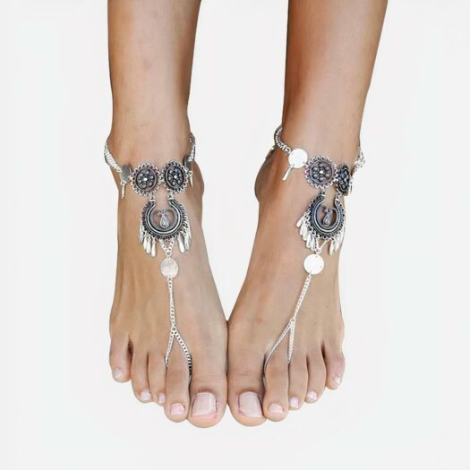 Photo de pieds de femme ornés de bracelets en métal de style bohème chic sur un fond blanc