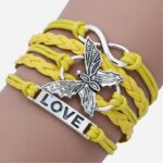 Un bracelet cordon jaune avec un papillon et une plaque où il est indiqué love
