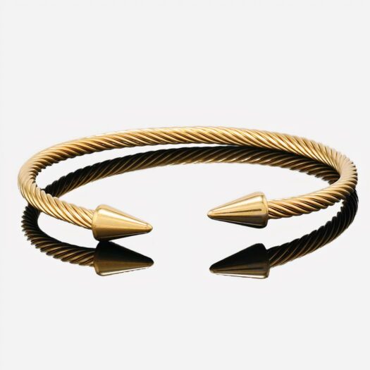 Bracelet jonc en pointe doré sur fond gris.