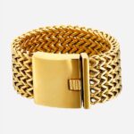 Bracelet en maille dorée sur fond blanc.