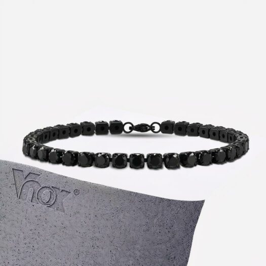 Photo d'un bracelet tennis pour homme de couleur noire sur un socle gris rectangulaire avec la marque gravée à gauche, le tout sur fond gris clair