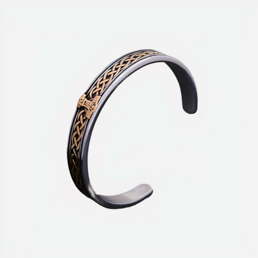 Bracelet en métal argenté avec des torsades dorées. Un motif viking doré au milieu