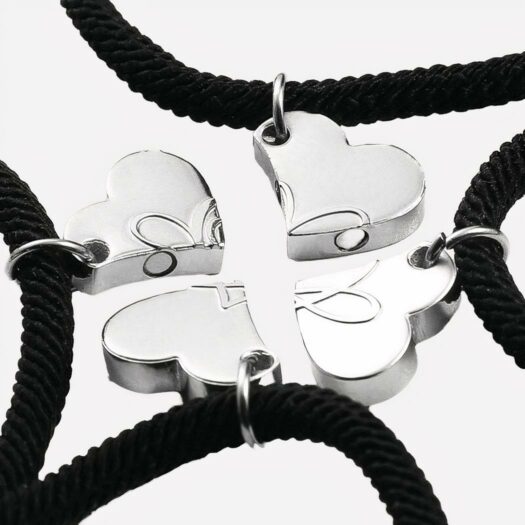 On voit quatre bracelets de l'amitié ornés d'un coeur qui se rassemblent pour former un trèfle
