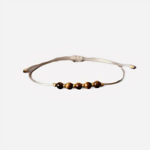 Photo d'un bracelet oeil de tigre marron avec cordon beige pour garçons et adolescents réglable sur un fond gris