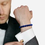 Homme costume qui porte un bracelet en lapis lazuli bleu
