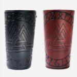 Photo de deux bracelts de force en cuir synthétique, l'un noir et l'autre marron longs à motifs géométriques triangulaires gravés, sur un fond blanc