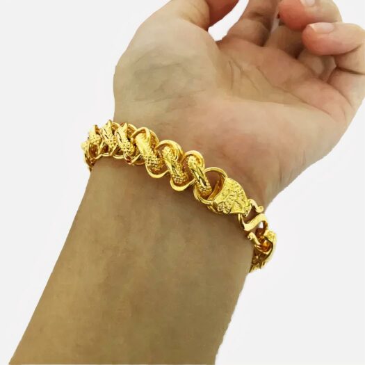 Poignet portant un bracelet en or.