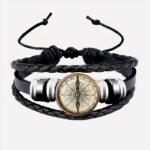 Bracelet noir avec une boussole sur fond blanc.