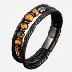 Photo d'un bracelet en cuir noir tressé et pierres naturelles oeil de tigre jaune rondes, fermoir magnétique.