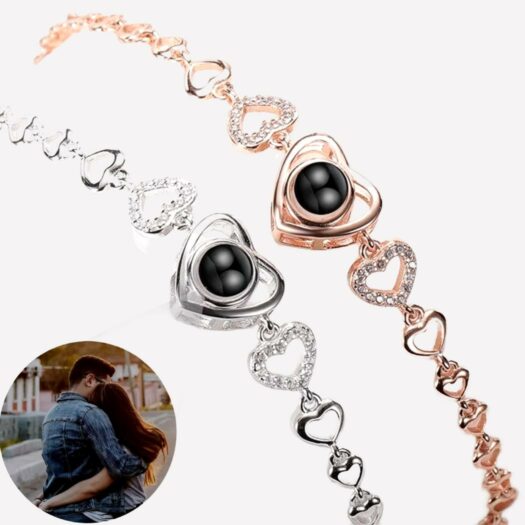2 bracelets, un argenté et un rose doré avec des mailles en forme de coeur et un grand coeur au milieu il y a une pierre noire. Une petite photo ronde d'un couple