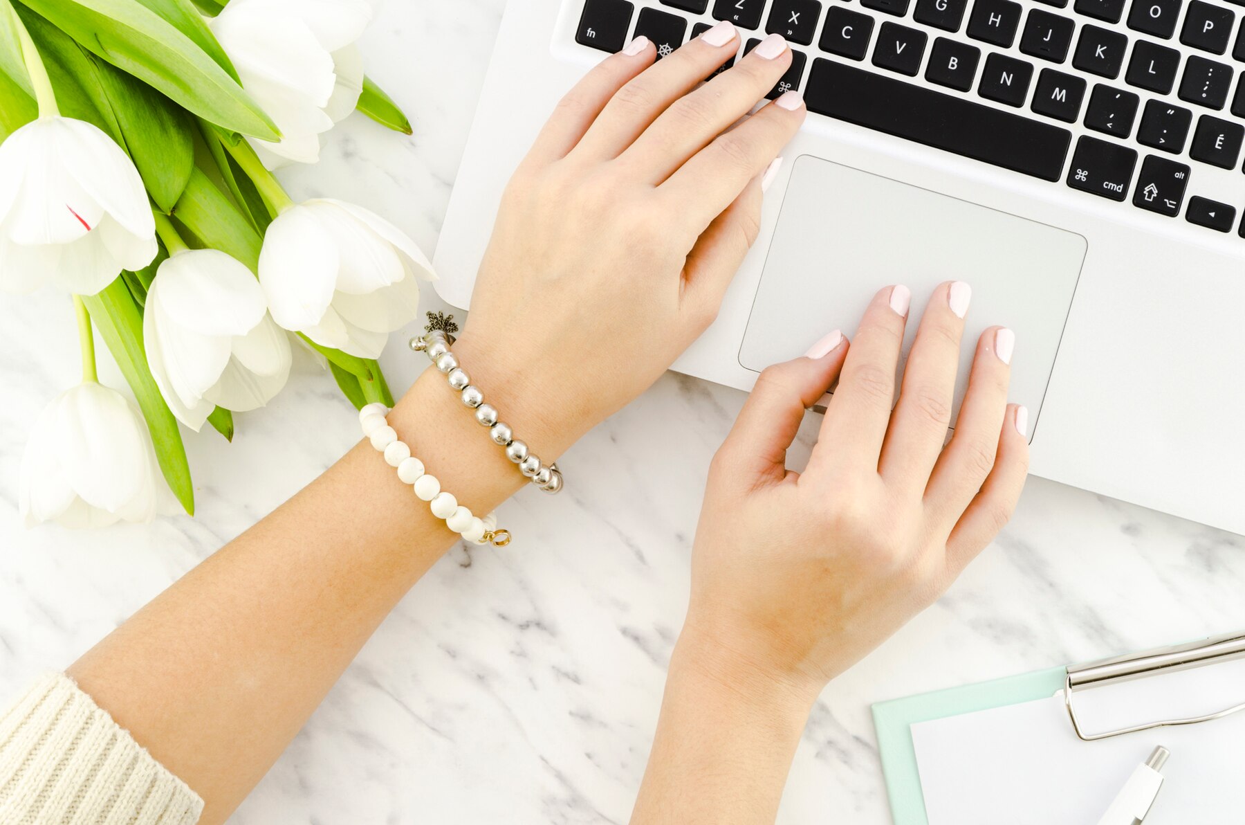 person-typing-laptop-keyboard-near-tulips_23-2148100651