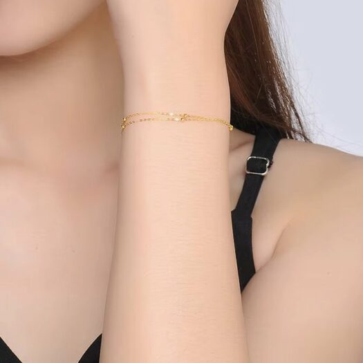 Femme qui porte un bracelet double rang or