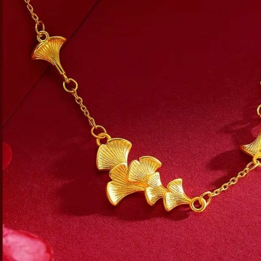 Bracelet or motifs ginkgo doré fond rouge