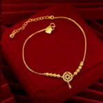 Bracelet plaqué or chaîne ajustable sur coussin rouge