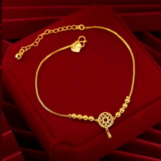 Bracelet plaqué or chaîne ajustable sur coussin rouge